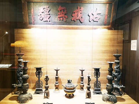 請火的香擔、焚香的香爐、燭台、懸掛的匾額，浯島城隍廟於地下的陳列展示空間展出相關文物。其中「佑我無疆」這塊匾額是光緒八年間的文物，具有久遠的歷史。（詹宗翰攝）