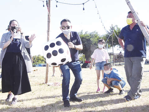 〈金門湖畔野FUN市集〉在風光明媚的莒光湖大草地舉行，豐富多樣的攤位吸引鄉親和遊客到訪，現場也有藝人演唱，縣長楊鎮浯昨（10）日下午來到現場，與民眾一起玩快閃擲骰子活動，也走訪各攤位以及各休息區，向商家、民眾問好致意。（莊煥寧攝）