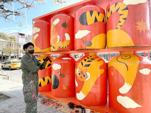 林務所春節布置陸續展開，其中，金湖鎮山外車站前，八個1000公升的大酒甕由金門插畫藝術家-吳騏，以「虎虎生風」的彩繪創作，述說希望以作品創造新年生生不息、永續流動的祝福意涵。（陳麗妤攝）