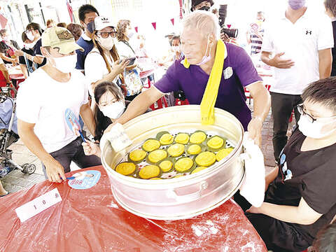熱騰騰的風獅爺紅龜粿新鮮出爐，民眾迫不及待想要大快朵頤一番。（陳麗妤攝）