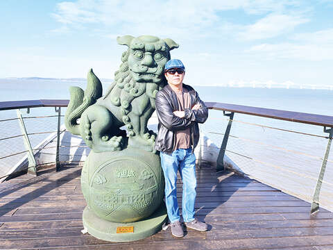 創作者王明宗於同安渡頭與作品合影。（許峻魁攝）